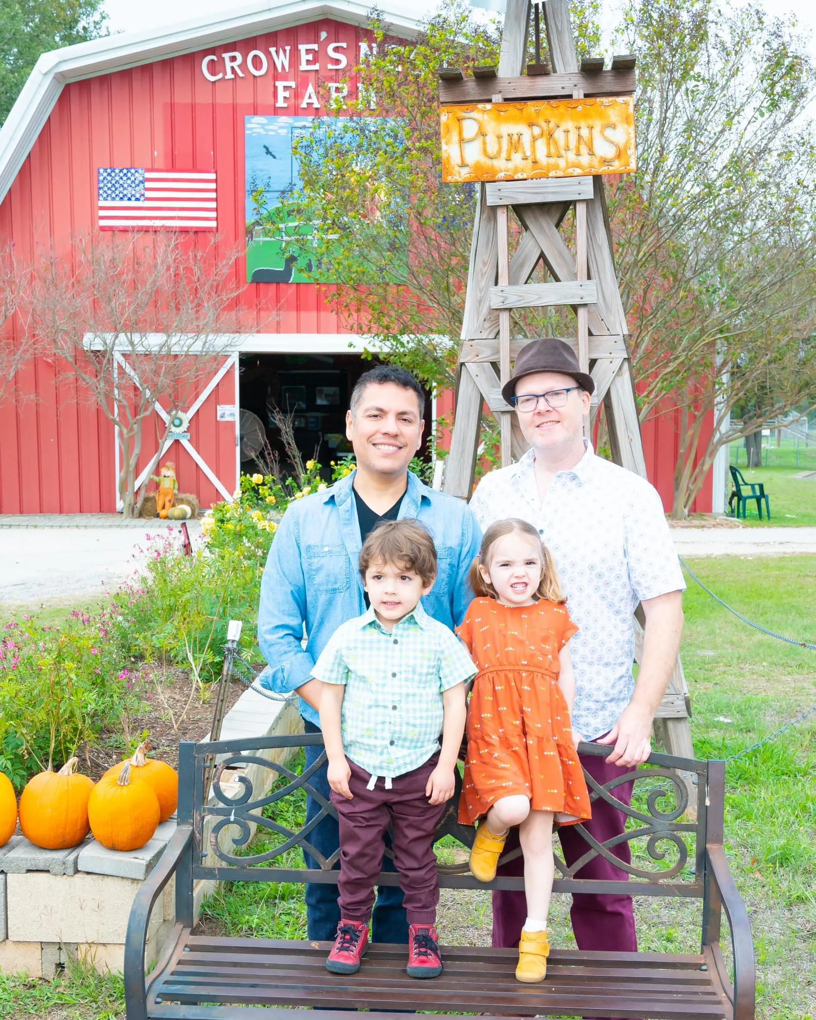 Joel and his family pose in front of a red barn.