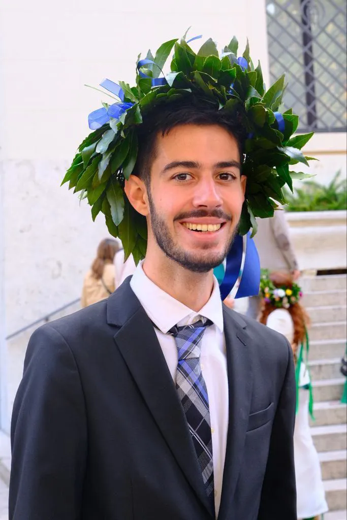 Luca smiling and wearing a laurel wreath on his graduation day