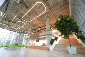 Modern office interior featuring high ceilings, unique lighting, and a staircase
