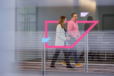 Two people walking in a modern office space